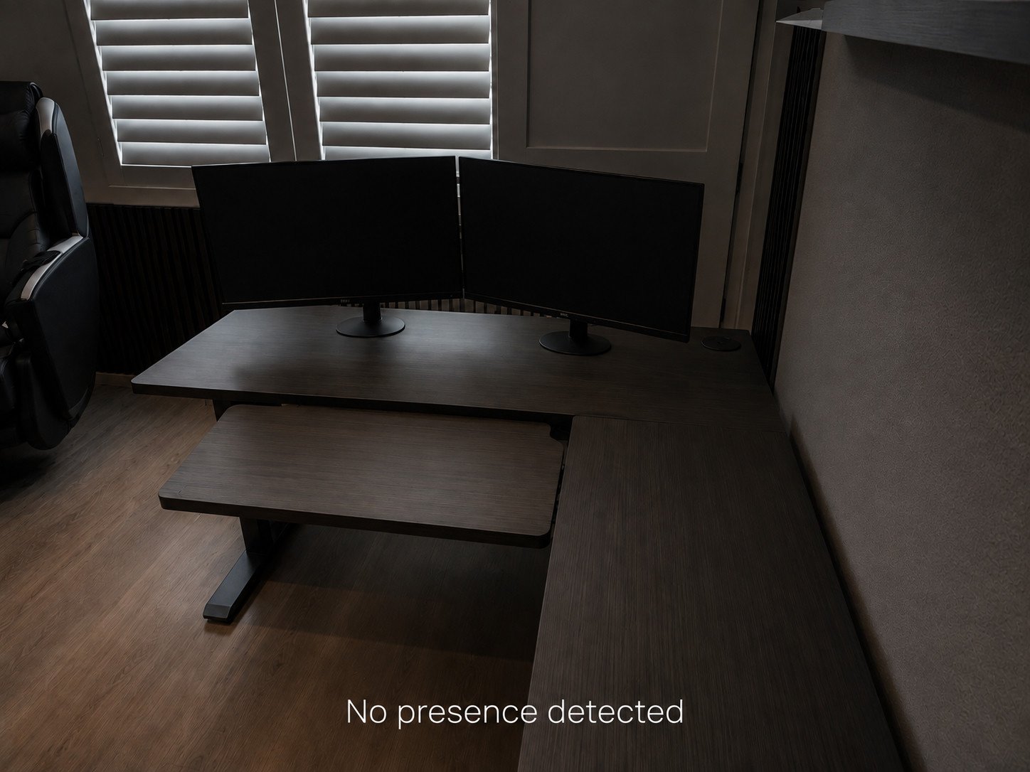 The same home office in darkness with both monitors switched off, labelled no presence detected